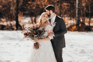 groom and bride holding bridal bouquet during winter wedding