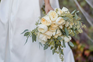 Bride holding bridal bouquet that is ivory and green