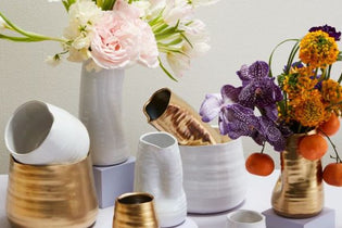 six white and gold vases with orange purple and pink flowers