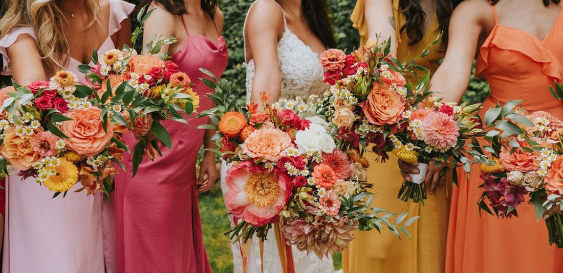 vibrant orange, pink, and yellow wedding flowers help by bridal party