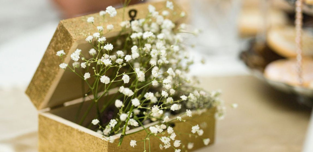 white baby's breath coming out of a sparkly gold box