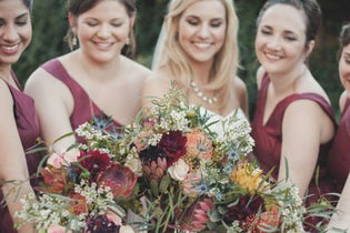 Bride and bridesmaids holding flower bouquets 