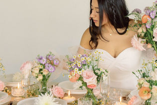 bride holding bouquet and setting up table with ethereal gardens flowers
