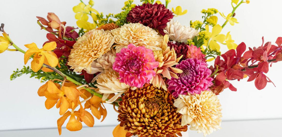 Yellow, orange, and pink arrangement in a white vase