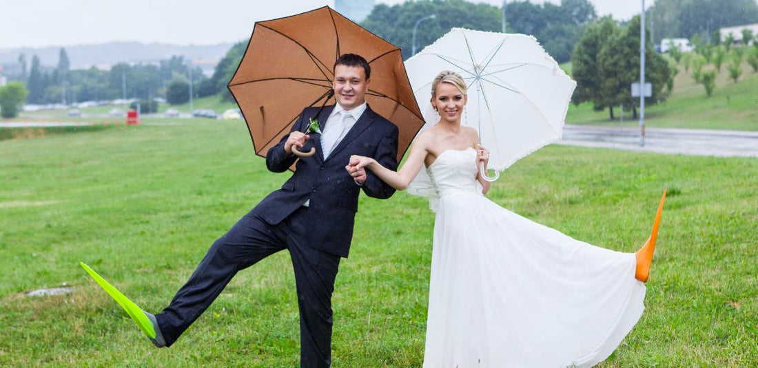 bride and groom under umbrellas with scuba flippers on their feet