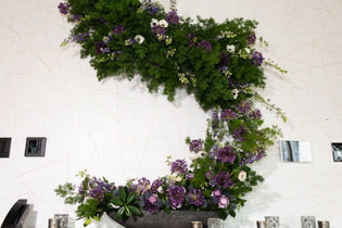 purple flowers with greenery arrangement flower wall