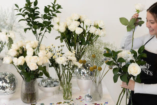 girl making bouquet at white new years eve bouquet bar