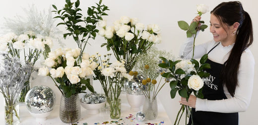 girl making bouquet at white new years eve bouquet bar