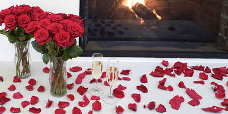 red rose bouquets and red rose petals in front of a fire place