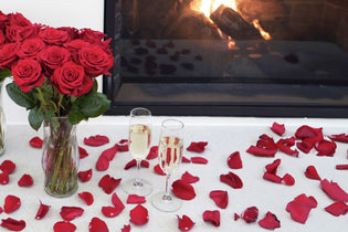 red rose bouquets and red rose petals in front of a fire place