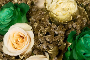 green roses, ivory roses, and golden flowers in a bouquet up close