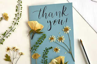 pressed flower card that is blue and says thank you!