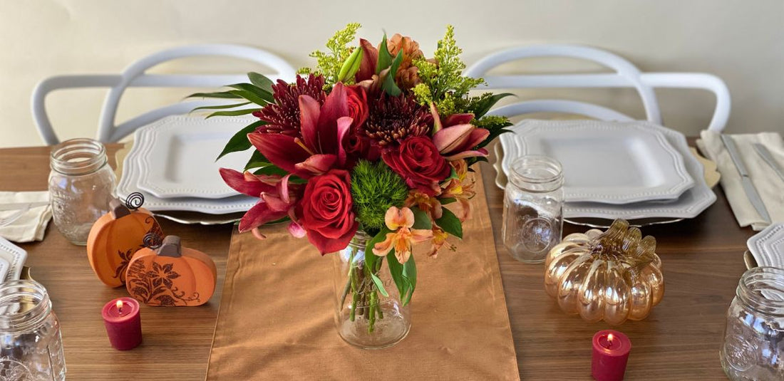 red and green and orange rustic table scape with fresh flowers in a mason jar