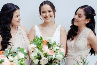 bride with her two maid of honors holding her bridal bouquet