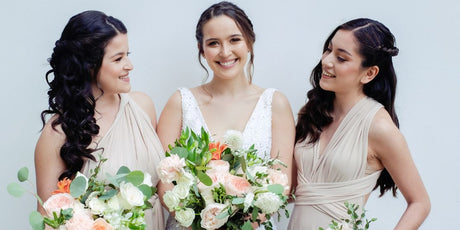 bride with her two maid of honors holding her bridal bouquet