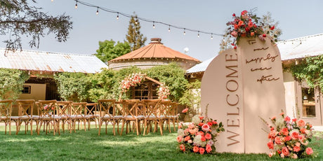 welcome sign with three flower arrangements on it