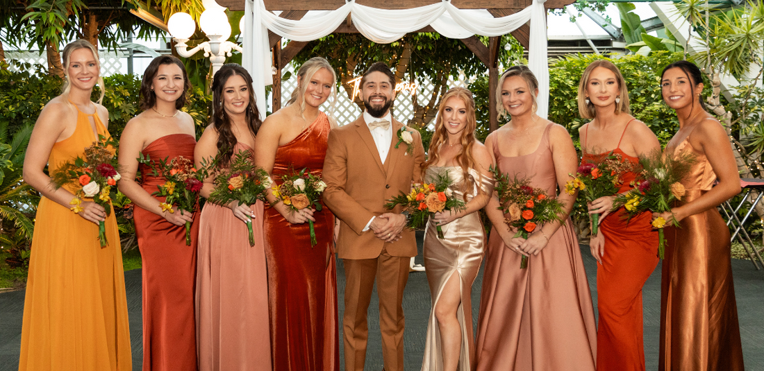 Bride and Groom standing with the bridesmaids holding their bouquets