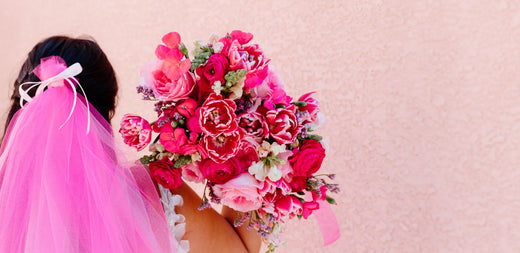 Bride with hot pink veil holding gummy pink bouquet over her right shoulder