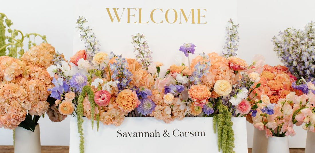 Peach, purple, and pink flower welcome sign