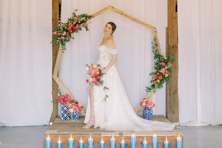 bride at alter with geometric arch with pink flowers and greenery