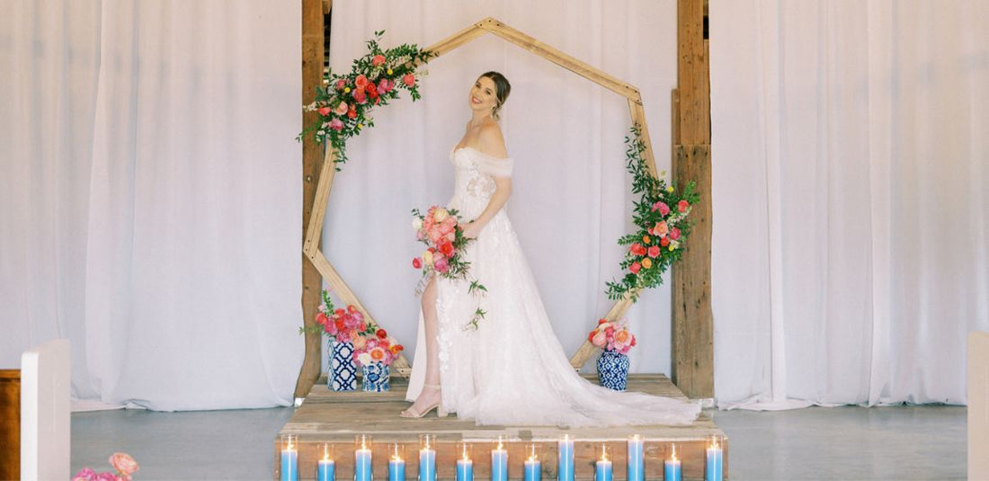 bride at alter with geometric arch with pink flowers and greenery