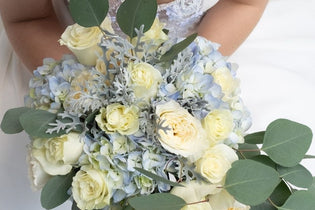 Bride holding a flower bouquet with hydrangeas in it.