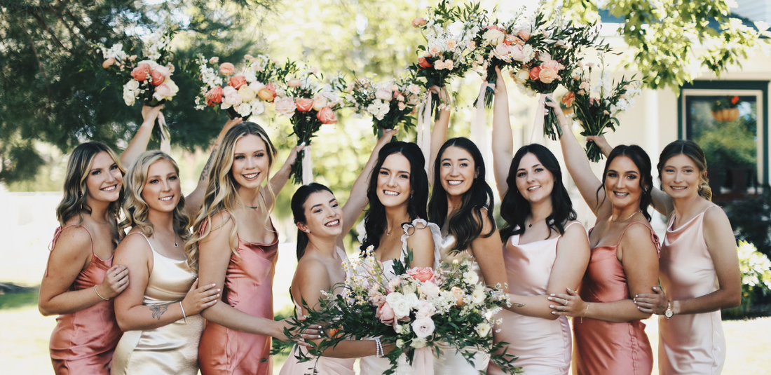Wedding Week Flower Checklist featured image of bride with bridesmaids holding pink and white garden bouquets