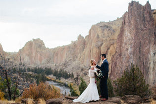 bride and groom standing in mountains