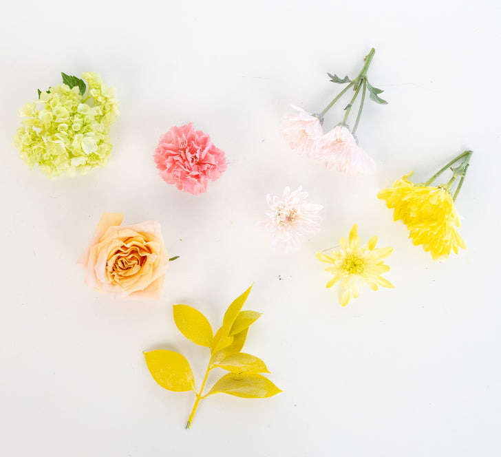 Flat lay of green hydrangea, pink carnation, peach garden rose and yellow mums from the Spring Fling Flower Collection