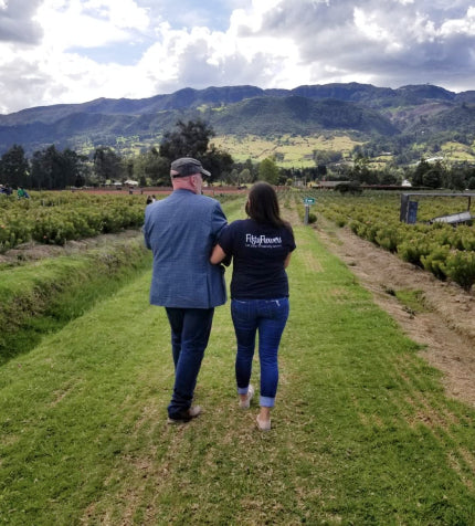 Two FiftyFlowers team members walking between rows of flowers at a partner farm in the Andes