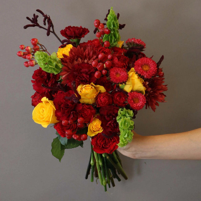 Crimson Sun Flower Arrangement in Hand