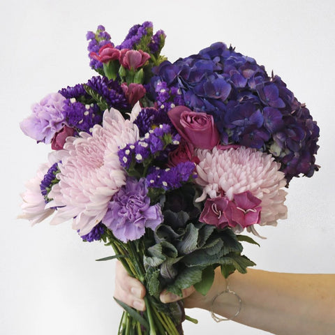 Pink and Purple Flower Arrangement in a Hand